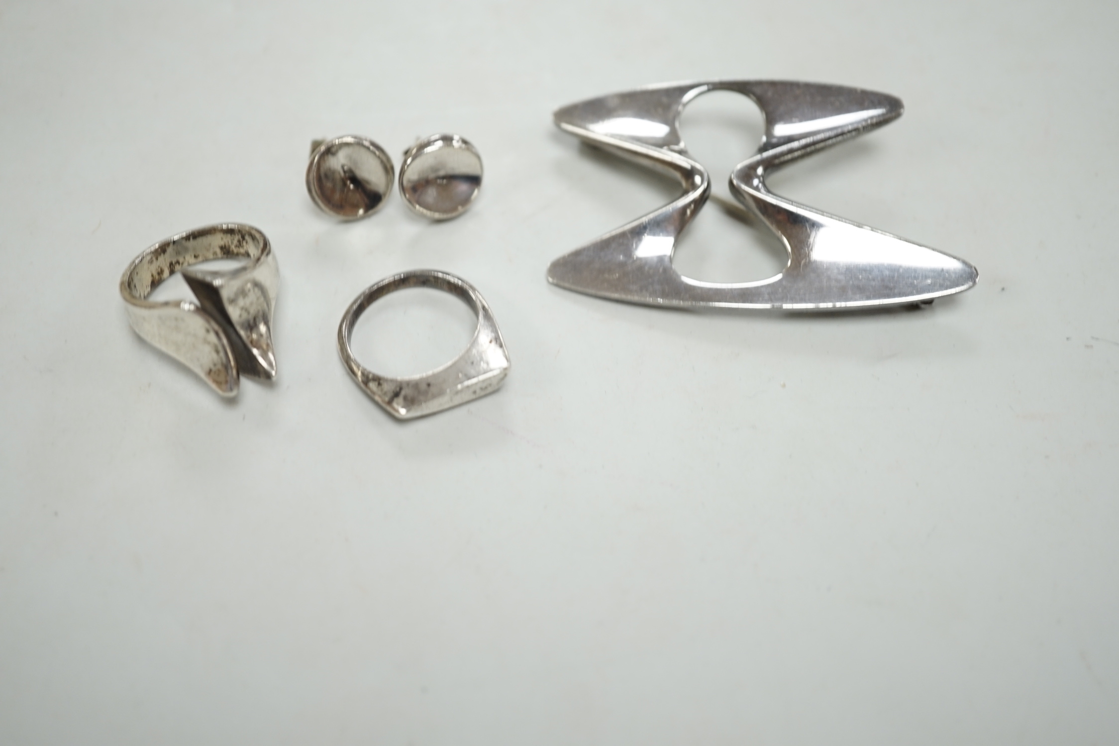 A Georg Jensen sterling free form brooch, design no. 369, a pair of Georg Jensen ear studs and two white metal rings.